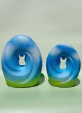 Load image into Gallery viewer, A pair of Meadow Song Pet Urns placed side by side, symbolizing peace and harmony with their soft blue and green hues.
