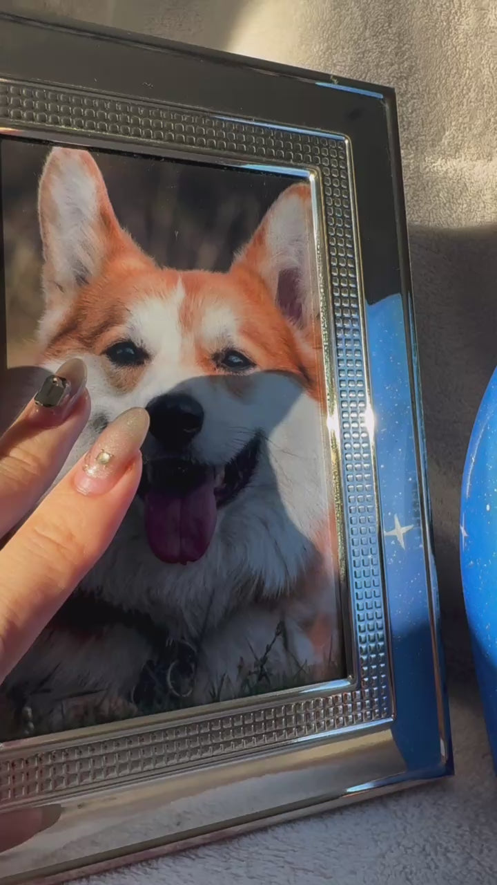 A close-up of a framed photo of a smiling dog, held by someone’s hand, evoking pet remembrance and cherished memories.